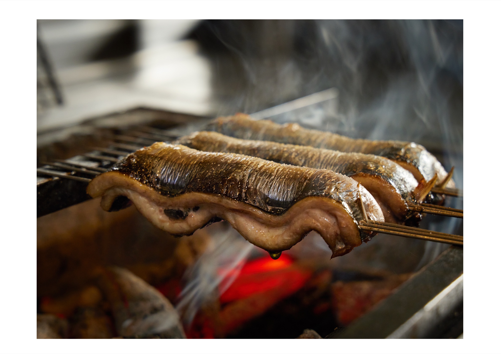銀座 矢部｜炭火で焼かれる秋刀魚の塩焼き。立ちのぼる煙